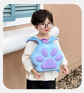 Vue avant d'un enfant portant un sac à dos bleu clair en coque EVA avec motifs de patte