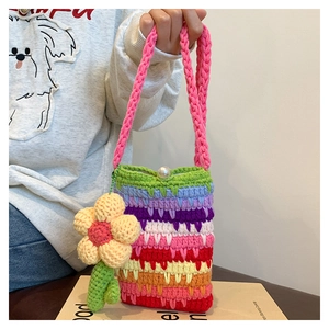 Detailaufnahme der Regenbogen-Häkeltasche mit Perlenverschluss und Blumenanhänger