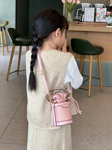 Detail of pink PU leather mini drawstring bucket bag for kids with gold metal buckle