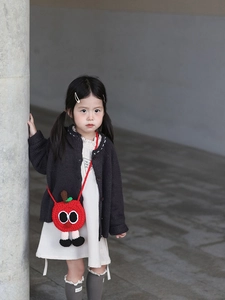 Gros plan d'un sac à bandoulière en crochet pomme rouge avec des yeux de dessin animé