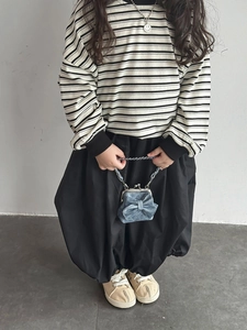 Detail eines Kindes mit Denim-Clip-Tasche mit Schleife und schwarz-weiß gestreiftem Shirt