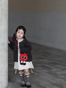 Détail du sac bandoulière pomme au crochet rouge avec de grands yeux et pieds