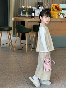 Close-up of beige speckled knit vest and skirt set for girls with pink drawstring bucket bag