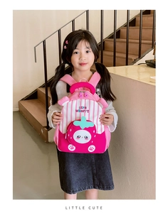 Girl holding strawberry patterned backpack with cute cartoon face and pink stripe details