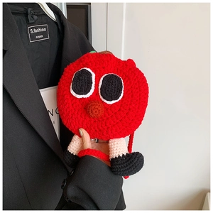 Gros plan d'un sac bandoulière pomme fait main au crochet avec visage de dessin animé
