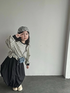 Detail einer blauen Umhängetasche mit Schleife auf einem stylischen Kinderoutfit