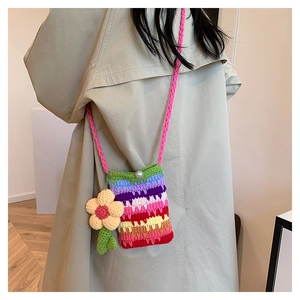 Detailaufnahme der Regenbogen-Häkeltasche mit Sonnenblumen-Anhänger am Mantel