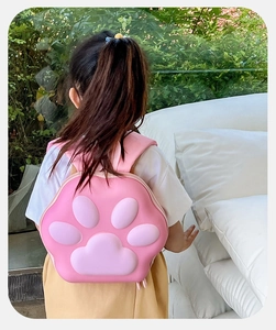 Enfant portant un sac à dos rigide en forme de patte de chat 3D rose en extérieur