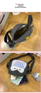 Interior storage view of grey penguin shoulder bag showing capacity for phone and accessories