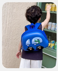 Vue détaillée du sac à dos voiture bleu avec motif de dinosaure porté par un enfant