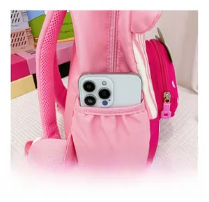 Detail of pink strawberry backpack side pocket showing capacity with a mobile phone