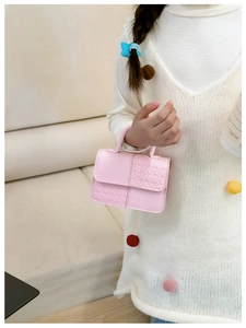 Détail d'un mini sac rose pour enfants avec textures en cuir lisse et tressé mélangées