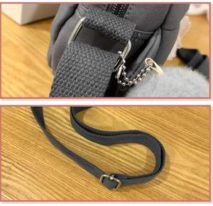 Detail of grey canvas bag showing silver metal rings, bead chain, and adjustable strap