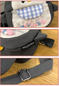 Detail of penguin crossbody bag featuring colorful pom-poms and adjustable strap