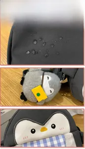 Detail of waterproof fabric with water droplets and plush penguin bag charm accessory