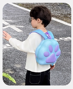 Vue extérieure d'un sac à dos rigide en forme de patte de chat bleu porté par un enfant