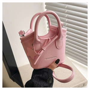 Detailed view of pink textured leather tote bag with star pendant and shoulder strap