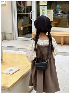 Détail d'un mini sac bandoulière noir pour enfants avec design en cuir tressé patchwork