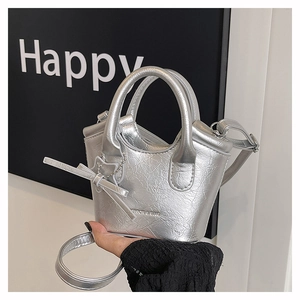 Detail of silver metallic mini tote bag with star pendant and glossy wrinkled texture