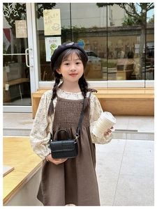 Détail d'un mini sac bandoulière noir tressé pour enfants et d'un béret élégant