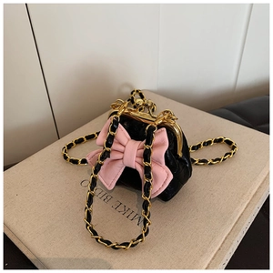 Detail einer schwarzen Stepptasche mit rosa Schleife und goldenem Klippverschluss