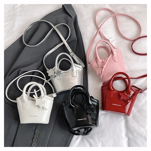 Flat lay of mini crossbody bags in silver pink white black and red with star charms