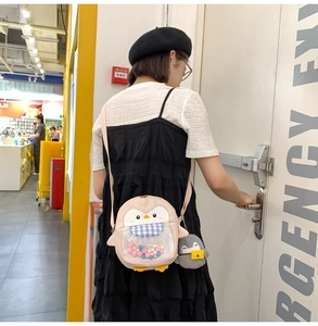 Cute pink penguin crossbody bag with colorful fur balls and a cartoon charm decoration