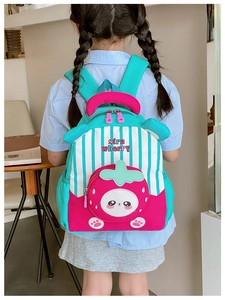 Detail view of colorful kids backpack with strawberry motifs and striped design on child model