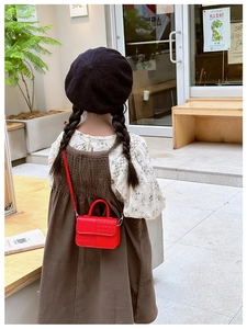 Détail du mini sac bandoulière rouge en cuir PU avec texture tissée et poignée enfant