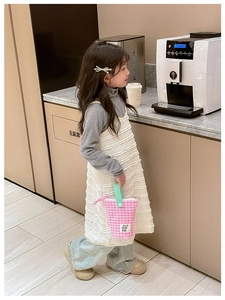 Détail du tissu blanc texturé plissé et du petit sac à main à carreaux stylé