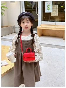 Détail d'un mini sac à main rouge pour enfants avec texture cœur sur fond extérieur