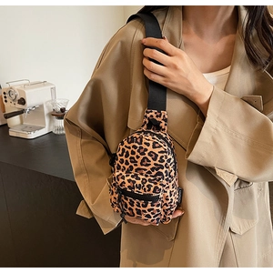 Close-up of leopard print canvas crossbody chest bag with black zipper detail and strap