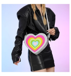 Detail of silver heart-shaped crossbody bag with rainbow concentric pattern on model