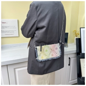 Detail of colorful gradient denim crossbody bag with star pattern and silver chain strap