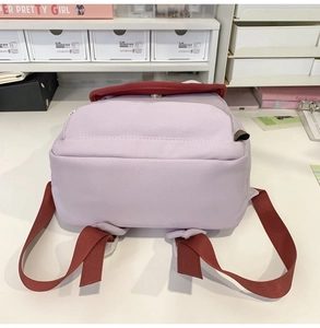 Detail view of the durable canvas backpack bottom and widened purple shoulder straps