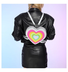 Detail view of heart-shaped Y2K backpack with rainbow pattern on a fashion model