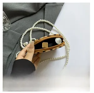 Internal view of leopard print mini bag with pearl chain showing lipstick storage capacity