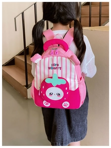 Close-up of cute strawberry print kids backpack with pink stripes and 3D details