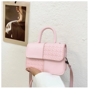 Vue détaillée du mini sac à main rose avec texture cuir lisse et tissé contrastée