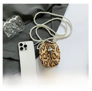 Detail view of mini leopard print faux fur bag with pearl chain and heart pendant