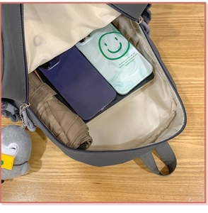 Interior view of grey penguin backpack showing storage for phone and folding umbrella
