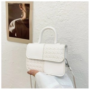 Détail d'un mini sac à main blanc avec texture damier tressée et poignée supérieure