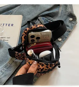 Internal view of leopard print mini crossbody bag showing storage for phone and accessories