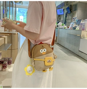 Détail du sac à bandoulière poussin cartoon porté avec porte-clés peluche canard jaune
