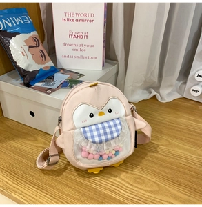 Detail of pink penguin bag featuring a transparent window filled with colorful plush balls