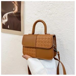 Détail du mini sac à main caramel avec texture tressée et poignée supérieure fixe