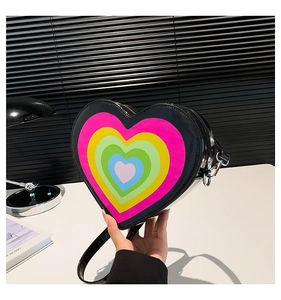 Detail of heart-shaped patent leather crossbody bag with colorful rainbow gradient patterns