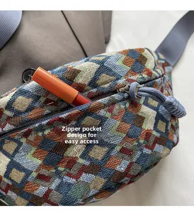 Close-up of ethnic style woven chest bag featuring a front zipper pocket for lipstick