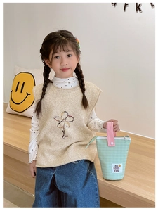 Détail de la trousse rayée vert menthe avec poignée rose et étiquette à motif smiley