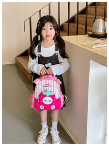 Close-up of pink strawberry kids backpack with cute cartoon pocket and stripe detail